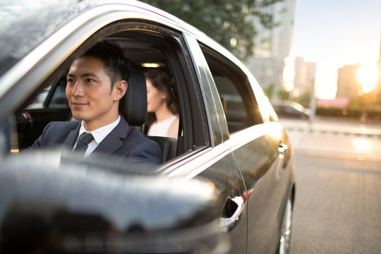 Young Chinese chauffeur driving car