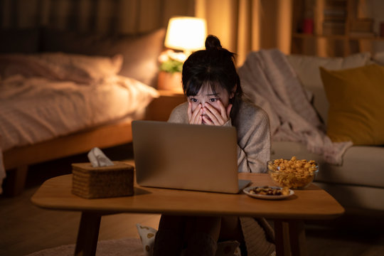 Young Chinese woman watching movie on laptop