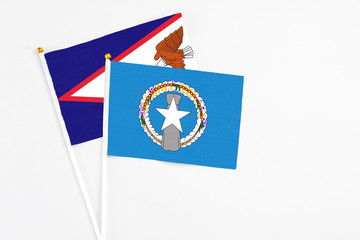 Northern Mariana Islands and American Samoa stick flags on white background. High quality fabric, miniature national flag. Peaceful global concept.White floor for copy space.