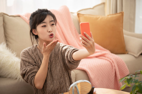 Young Chinese woman doing live webcast at home