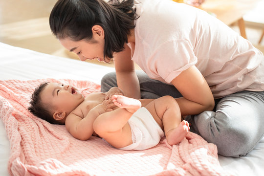 Young Chinese Mom Playing With Her Baby Girl