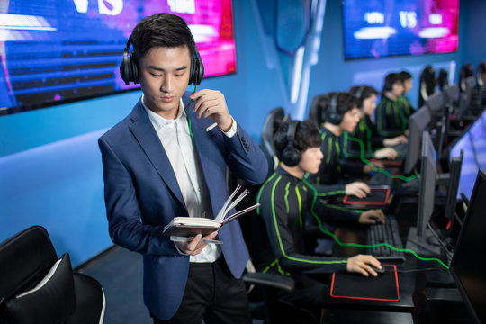 Young Chinese man coaching gamer playing esports