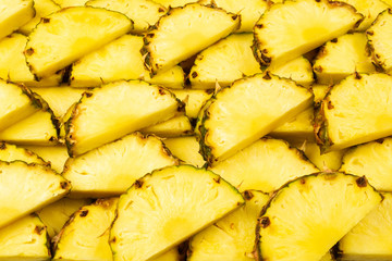 Pineapple juicy yellow slices background. Top view.