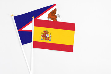 Spain and American Samoa stick flags on white background. High quality fabric, miniature national flag. Peaceful global concept.White floor for copy space.