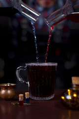 a mixture of blue and red liquids in a mug with details on the table