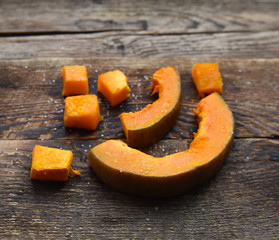 baked orange pumpkin sliced on a wooden table