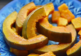 baked orange pumpkin sliced on a wooden table