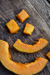 baked orange pumpkin sliced on a wooden table