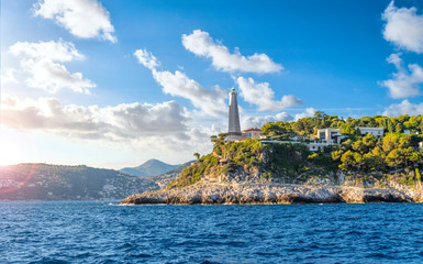 View from the Mediterranean Sea of the Saint Jean Cap Ferrat lighthouse as the sun begins to set on the French Riviera in the South of France.