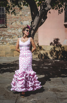 Eccentric woman in colorful pink costume on summer street