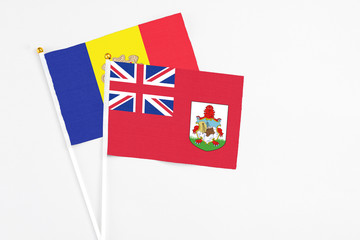Fototapeta premium Bermuda and Andorra stick flags on white background. High quality fabric, miniature national flag. Peaceful global concept.White floor for copy space.