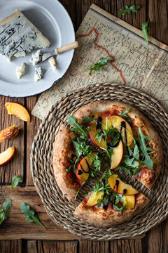 Delicious fresh summer pizza placed on timber table in rustic kitchen