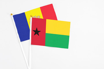 Guinea Bissau and Andorra stick flags on white background. High quality fabric, miniature national flag. Peaceful global concept.White floor for copy space.
