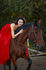 Beautiful young woman with horse outdoors