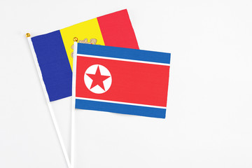 North Korea and Andorra stick flags on white background. High quality fabric, miniature national flag. Peaceful global concept.White floor for copy space.