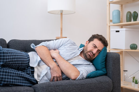 Man Lying On The Sofa Feeling Pain And Stomachache