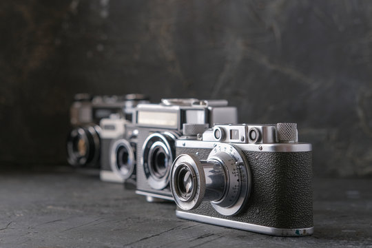 Old antique film cameras against a dark background.
