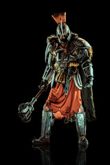 Powerful knight in the armor with the hammer. Isolated on black background.