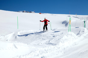 Fototapeta na wymiar Woman-skier jumping on the hillocks
