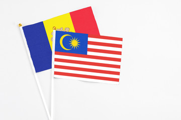 Malaysia and Andorra stick flags on white background. High quality fabric, miniature national flag. Peaceful global concept.White floor for copy space.