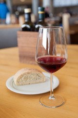 bread and red wine in a glass on the table