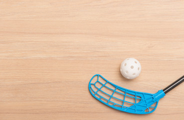 floorball stick and white ball isolated on wooden background