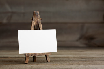 Standard sized empty white business card template with wooden easel. For branding identity, logo design pitches and marketing.