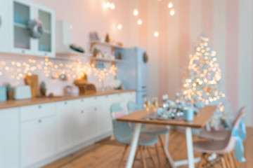 Defocused blurry Interior of modern white kitchen with pink walls and blue decor on a Christmas New year eve