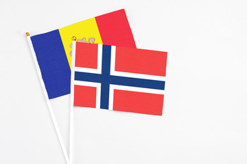 Obraz premium Norway and Andorra stick flags on white background. High quality fabric, miniature national flag. Peaceful global concept.White floor for copy space.