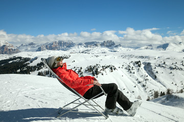 woman-skier  on a sun lounger in the mountains in winter - 302312289