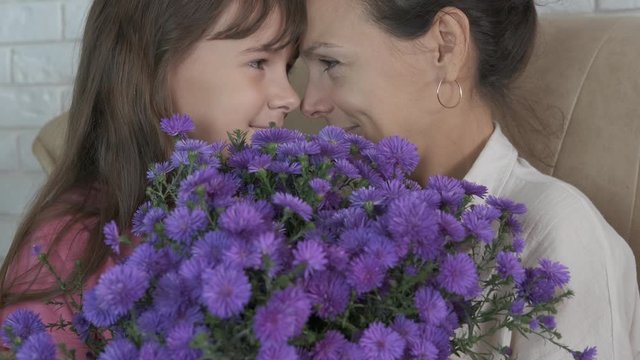 Flowers for mom. Portrait of mother and daughter with a bouquet of flowers.