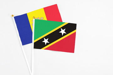 Saint Kitts And Nevis and Andorra stick flags on white background. High quality fabric, miniature national flag. Peaceful global concept.White floor for copy space.