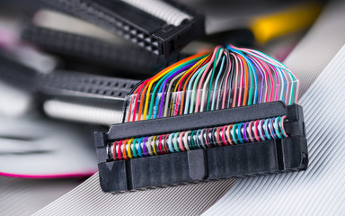 Colored multi wire connector. Ribbon cables detail in blurred background. Internal drive...