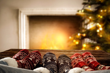 Woman legs with christms socks. Free space for your decoration. Xmas tree and fireplace. 