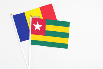 Togo and Andorra stick flags on white background. High quality fabric, miniature national flag. Peaceful global concept.White floor for copy space.