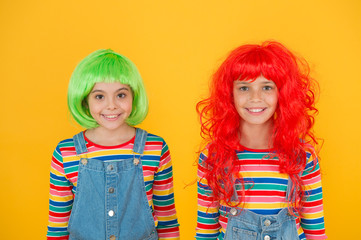 Fashionable and artistic. Happy children wear fashionable hair wigs yellow background. Little girls smile with fashionable look. Fashioanble hair salon. Fashion and style