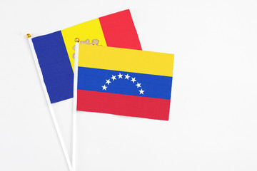 Venezuela and Andorra stick flags on white background. High quality fabric, miniature national flag. Peaceful global concept.White floor for copy space.