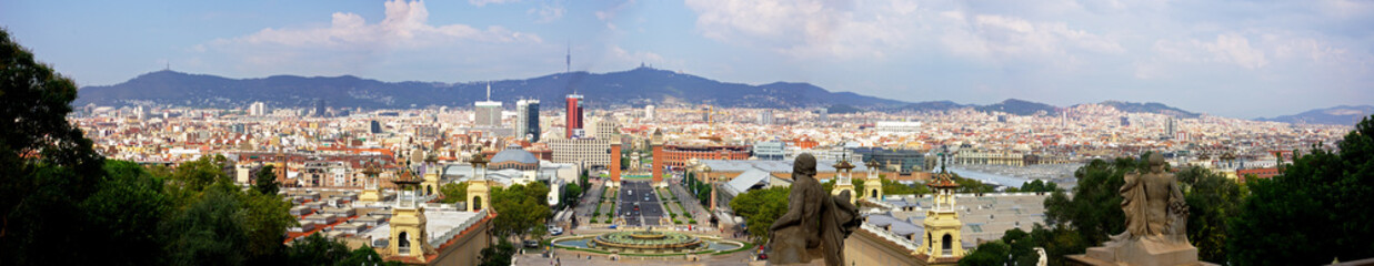 Fototapeta na wymiar Panoramic of Barcelona with the towers in the Plaza Espana, the bullring, the ancient sculptures and the mountains in the background