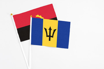 Barbados and Angola stick flags on white background. High quality fabric, miniature national flag. Peaceful global concept.White floor for copy space.