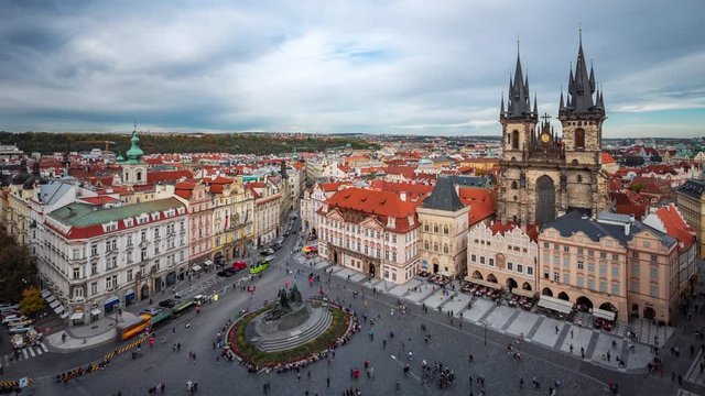Prague, Czech Republic, time lapse view of people and traffic around the Old Town Square showing gothic architectural landmarks during daytime in fall season.