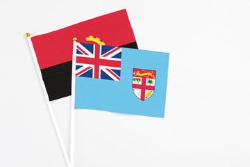 Fiji and Angola stick flags on white background. High quality fabric, miniature national flag....