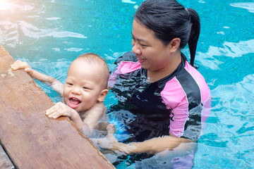 Happy asian mother and Cute lAsian 1 year old, 18 months toddler boy child playing near the...