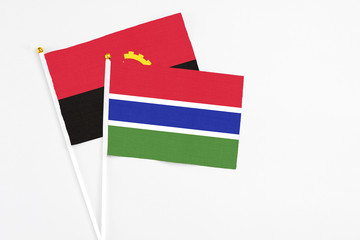 Gambia and Angola stick flags on white background. High quality fabric, miniature national flag. Peaceful global concept.White floor for copy space.
