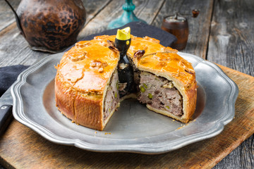Traditional French Pate en croute with goose meat and liver as closeup on a pewter plate