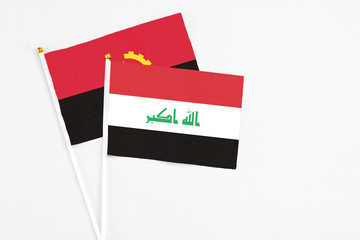 Iraq and Angola stick flags on white background. High quality fabric, miniature national flag. Peaceful global concept.White floor for copy space.