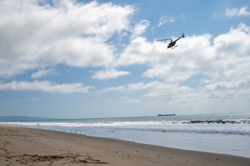 Helicopter patrols over the ocean beach