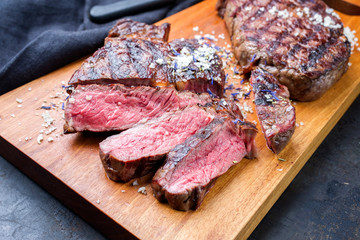 Traditional barbecue dry aged wagyu entrecote beef steak sliced with salt and spice as closeup on...