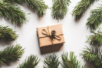 Gift box with christmas green framework and pine cones on white background. Copy space and Top view