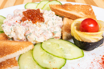 Salmon tartare with crackers and snacks.
