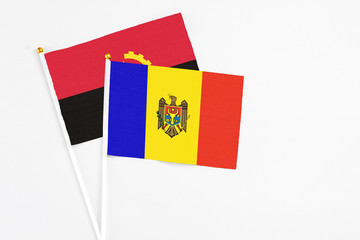 Moldova and Angola stick flags on white background. High quality fabric, miniature national flag. Peaceful global concept.White floor for copy space.